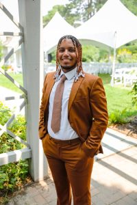 Yanci Almonte Vargas in a brown suit and tie