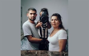 Couple with a child behind a camera